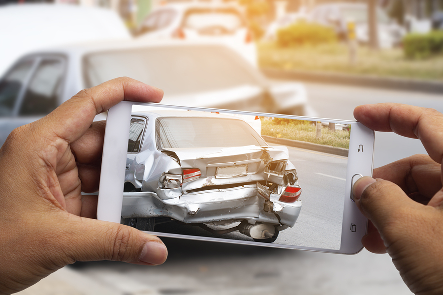 Person taking photo of wrecked car